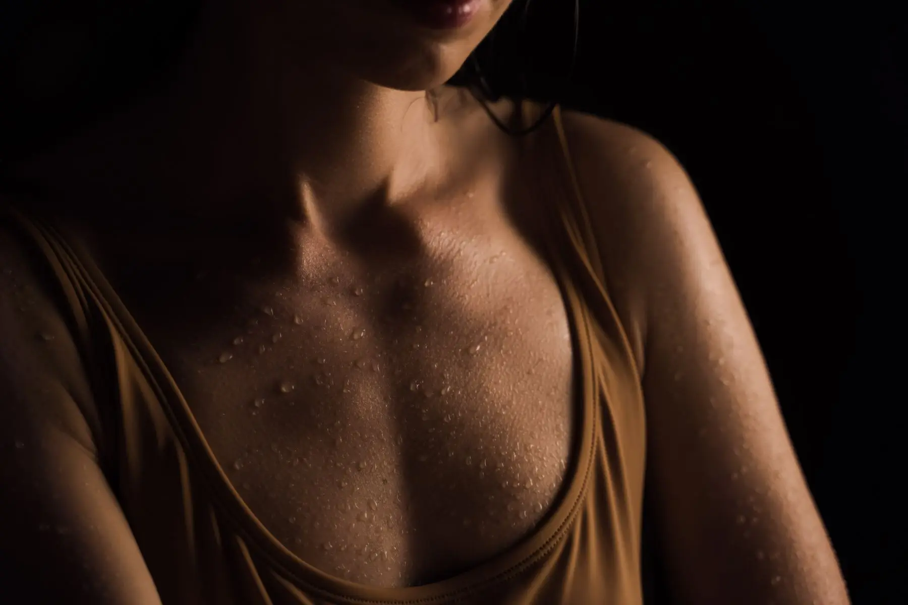 Detalle de piel con gotas de agua bajo luz cálida